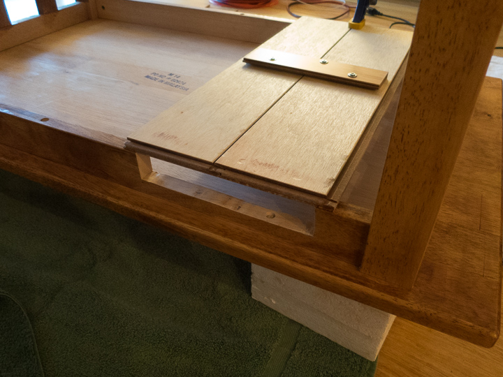 The table has been turned upside down showing the flooring planks that have been installed to act as the bottom of the nook.