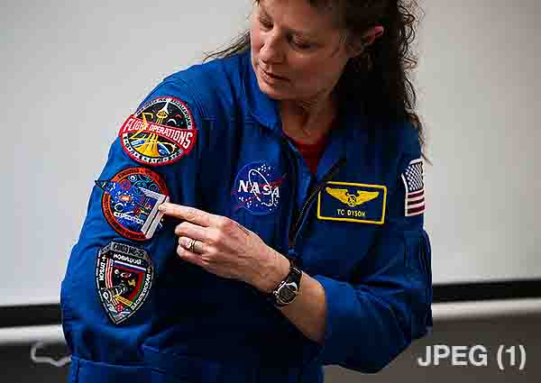 A low quality image of NASA Astronaut Tracy Dyson pointing to the Expedition 71 patch on her flight suit on Wednesday, March 5, 2025 at Elsie Whitlow Stokes Community Freedom Public Charter School in Washington, D.C. (Image credit: NASA/Joel Kowsky)